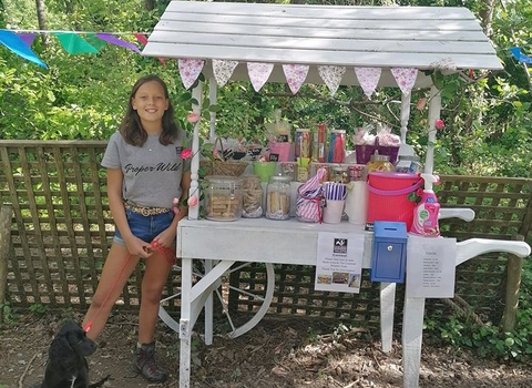 Izzy, 13, stands proudly by her sweet stall on the bissoe trail